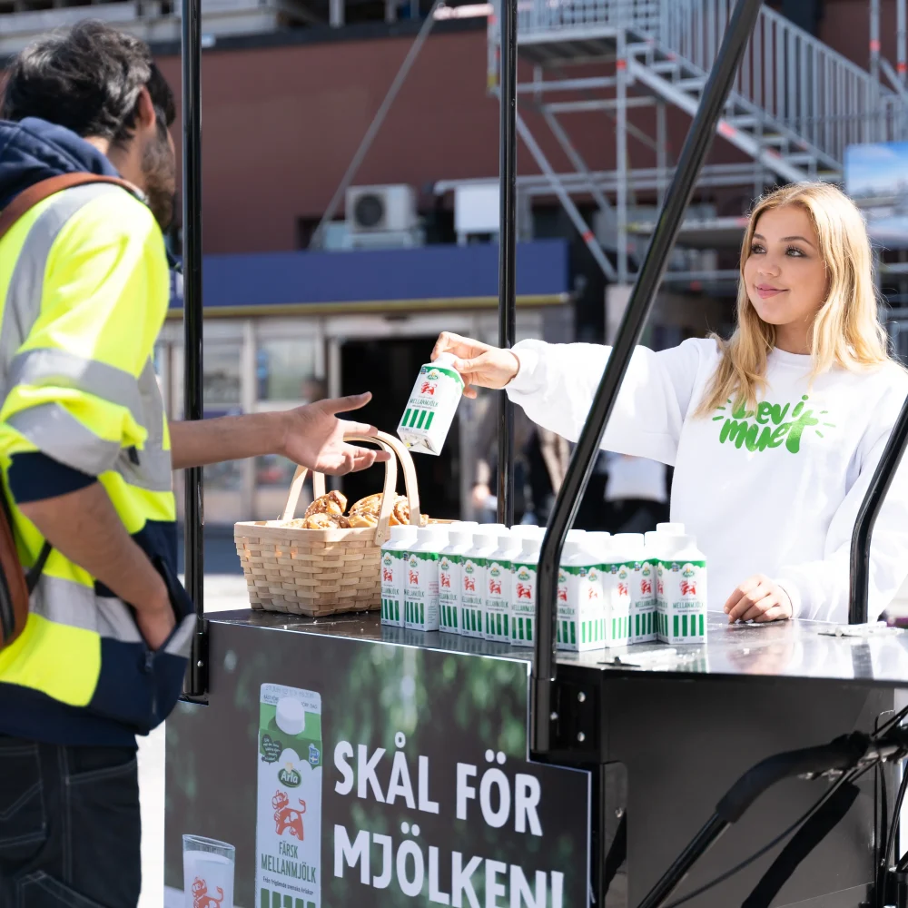 Eventpersonal delar ut produktsample för Arla